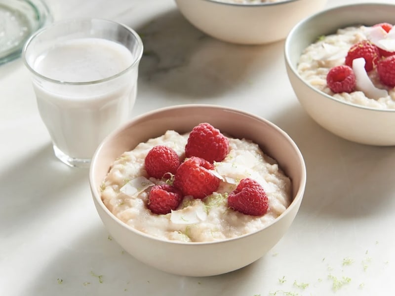 A bowl of rice pudding topped with raspberries A bowl of rice pudding topped with raspberries