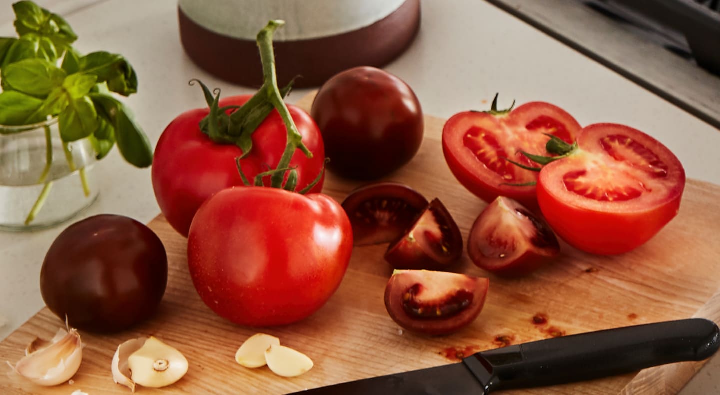 A cutting board piled with tomatoes A cutting board piled with tomatoes
