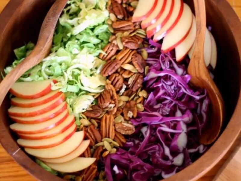 Salad bowl filled with chopped fruits, vegetables and nuts