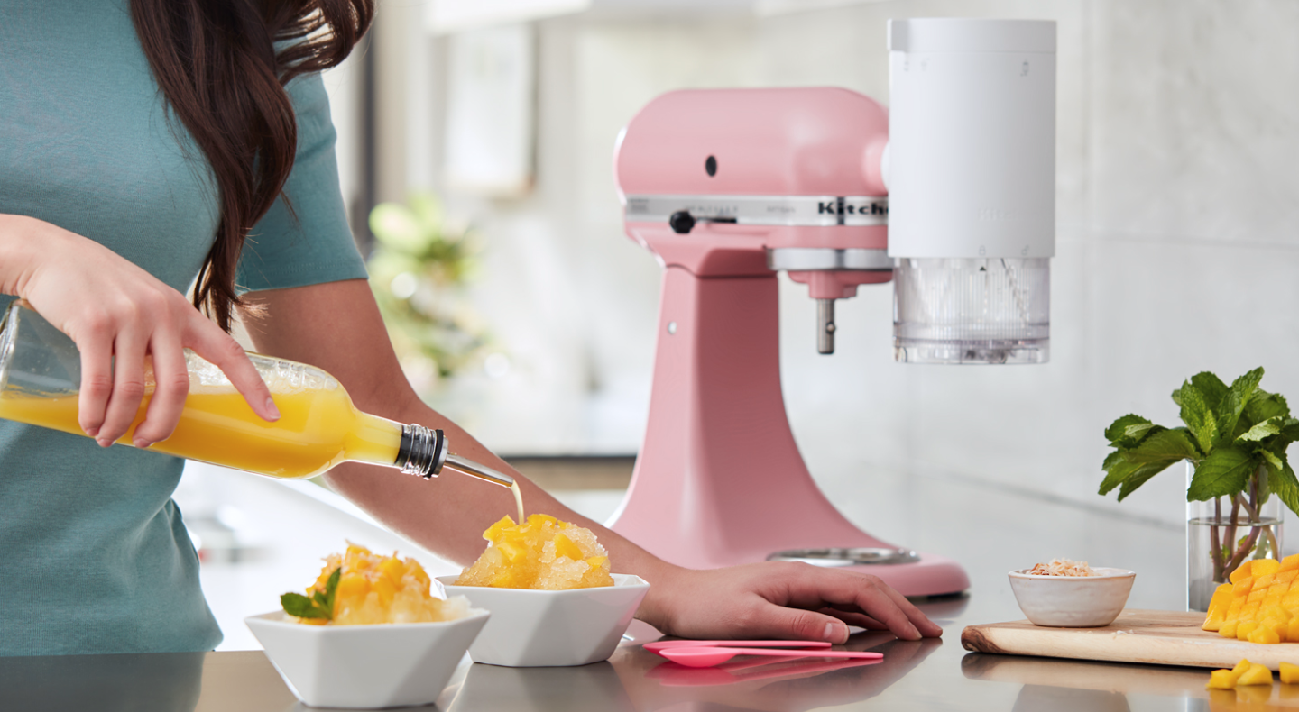 Orange syrup being poured on a bowl of shave ice Orange syrup being poured on a bowl of shave ice