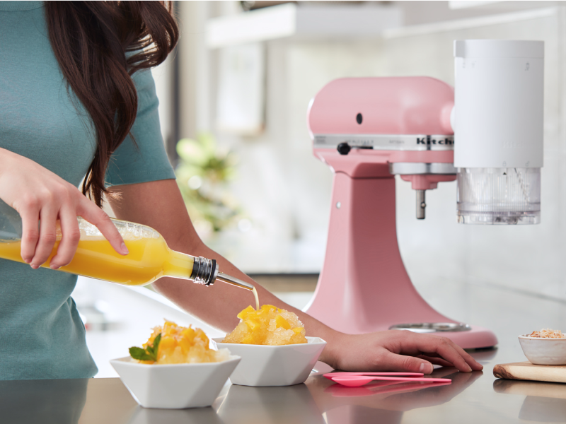 Orange syrup being poured on a bowl of shave ice Orange syrup being poured on a bowl of shave ice
