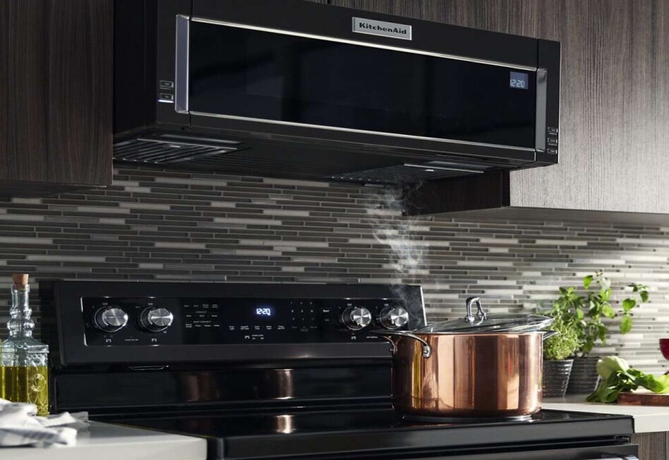 Pot of water with lid half-on boiling water on electric cooktop Pot of water with lid half-on boiling water on electric cooktop