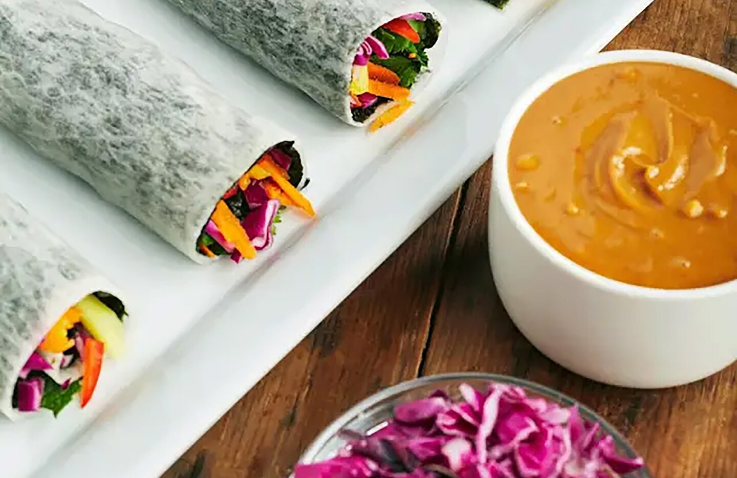 Rainbow spring rolls with shredded cabbage and peanut dipping sauce Rainbow spring rolls with shredded cabbage and peanut dipping sauce