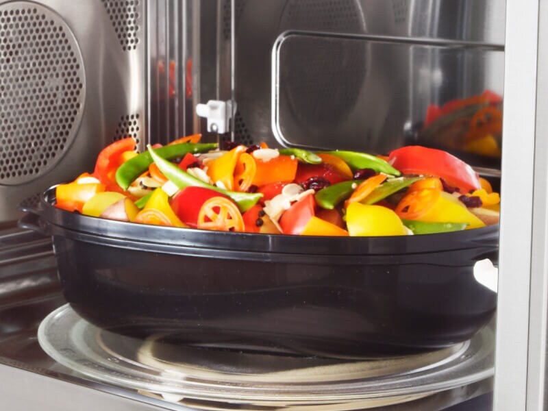 Vegetables in a container in a microwave Vegetables in a container in a microwave