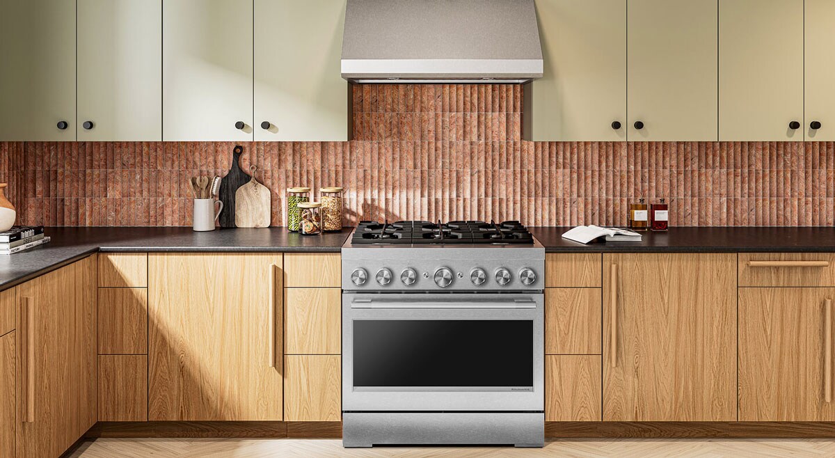 The interior of a kitchen with a stainless steel gas stovetop in it