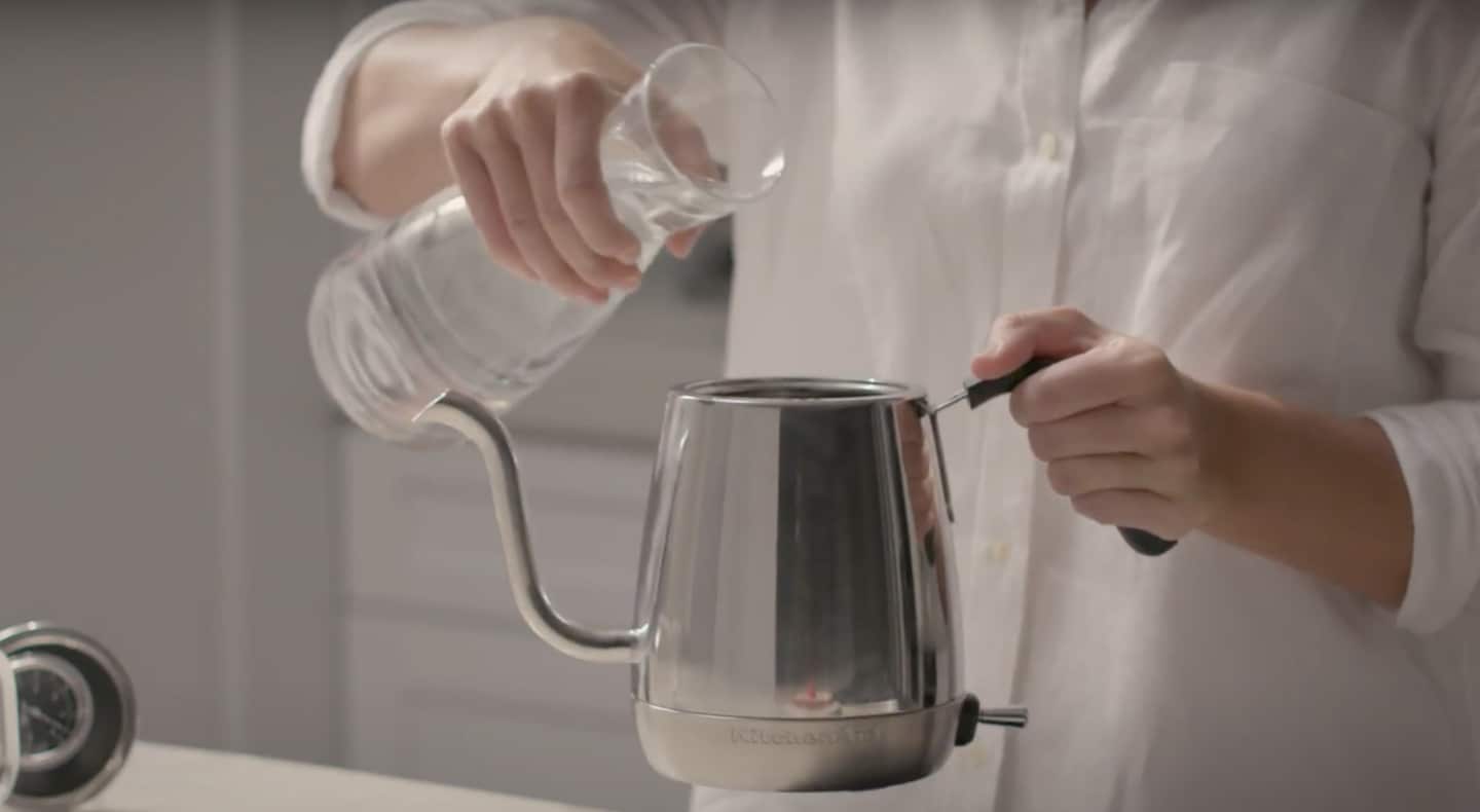 Maker pouring water into stainless steel KitchenAid® gooseneck kettle Maker pouring water into stainless steel KitchenAid® gooseneck kettle