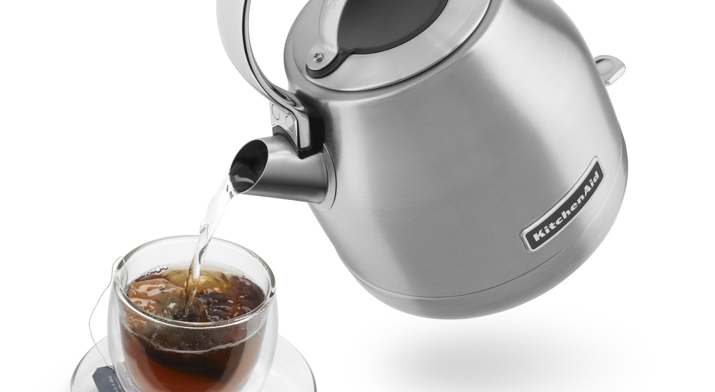 Hot water being poured from KitchenAid® kettle into glass of tea Hot water being poured from KitchenAid® kettle into glass of tea