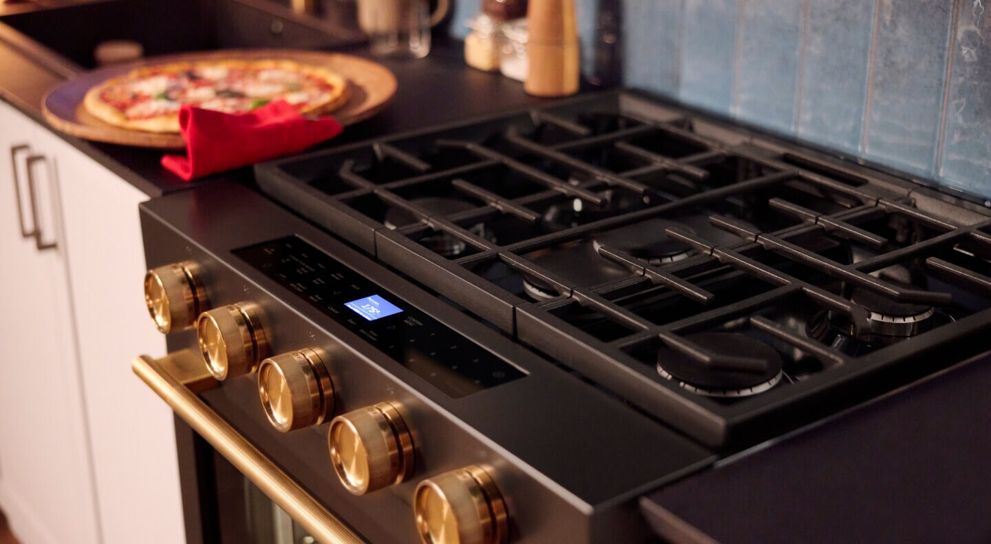 A kitchen with a KitchenAid® slide-in gas range with a pizza setting next to it