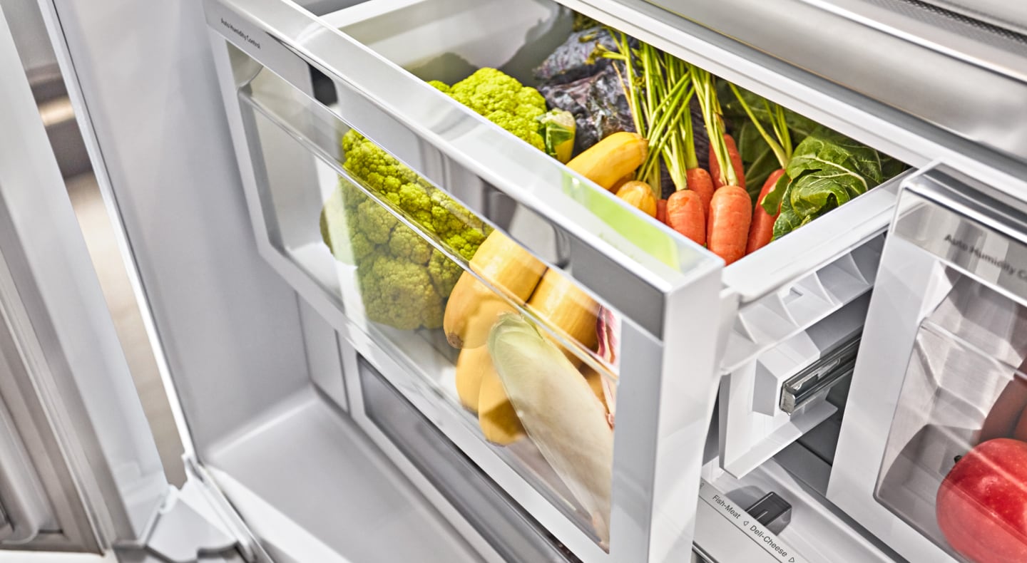 Assorted vegetables inside an open refrigerator crisper drawer Assorted vegetables inside an open refrigerator crisper drawer