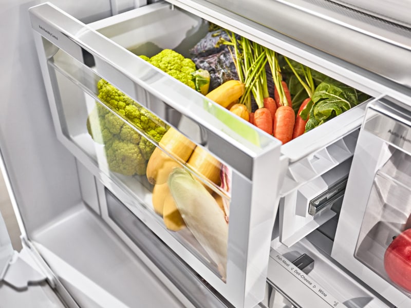 Assorted vegetables inside an open refrigerator crisper drawer Assorted vegetables inside an open refrigerator crisper drawer