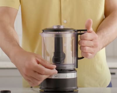 Person adjusting controls on food chopper
