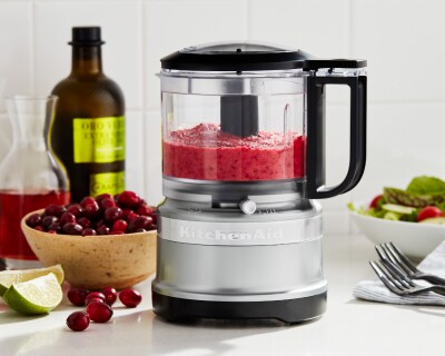 Silver food chopper filled with pureed fruit