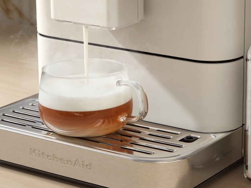 Frothed milk being poured over an espresso beverage Frothed milk being poured over an espresso beverage