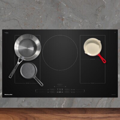 An induction cooktop with three pans on it An induction cooktop with three pans on it