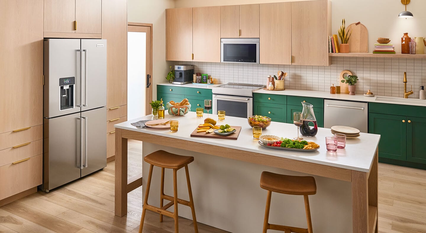 A bright kitchen island with veggie platters and wine on it A bright kitchen island with veggie platters and wine on it