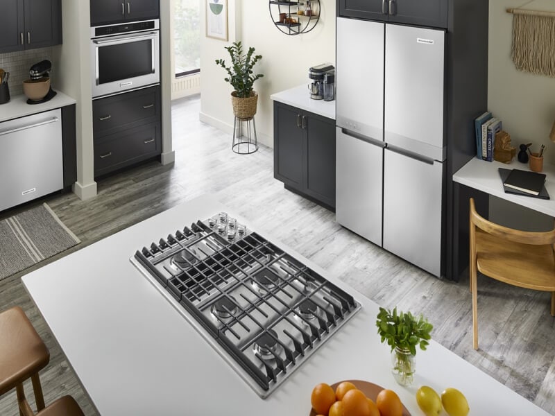 A bright kitchen with an island with a cooktop installed in it A bright kitchen with an island with a cooktop installed in it