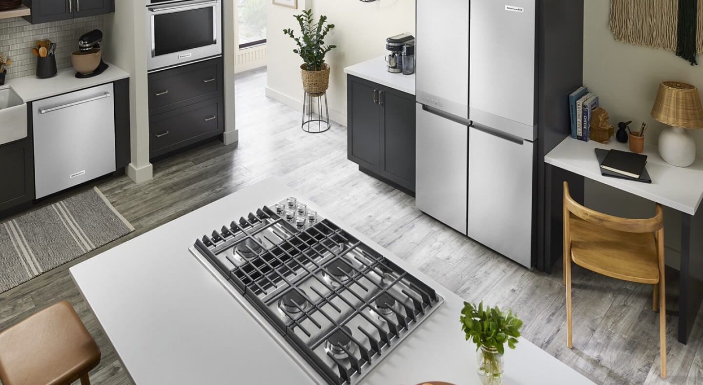 A bright kitchen with an island with a cooktop installed in it A bright kitchen with an island with a cooktop installed in it
