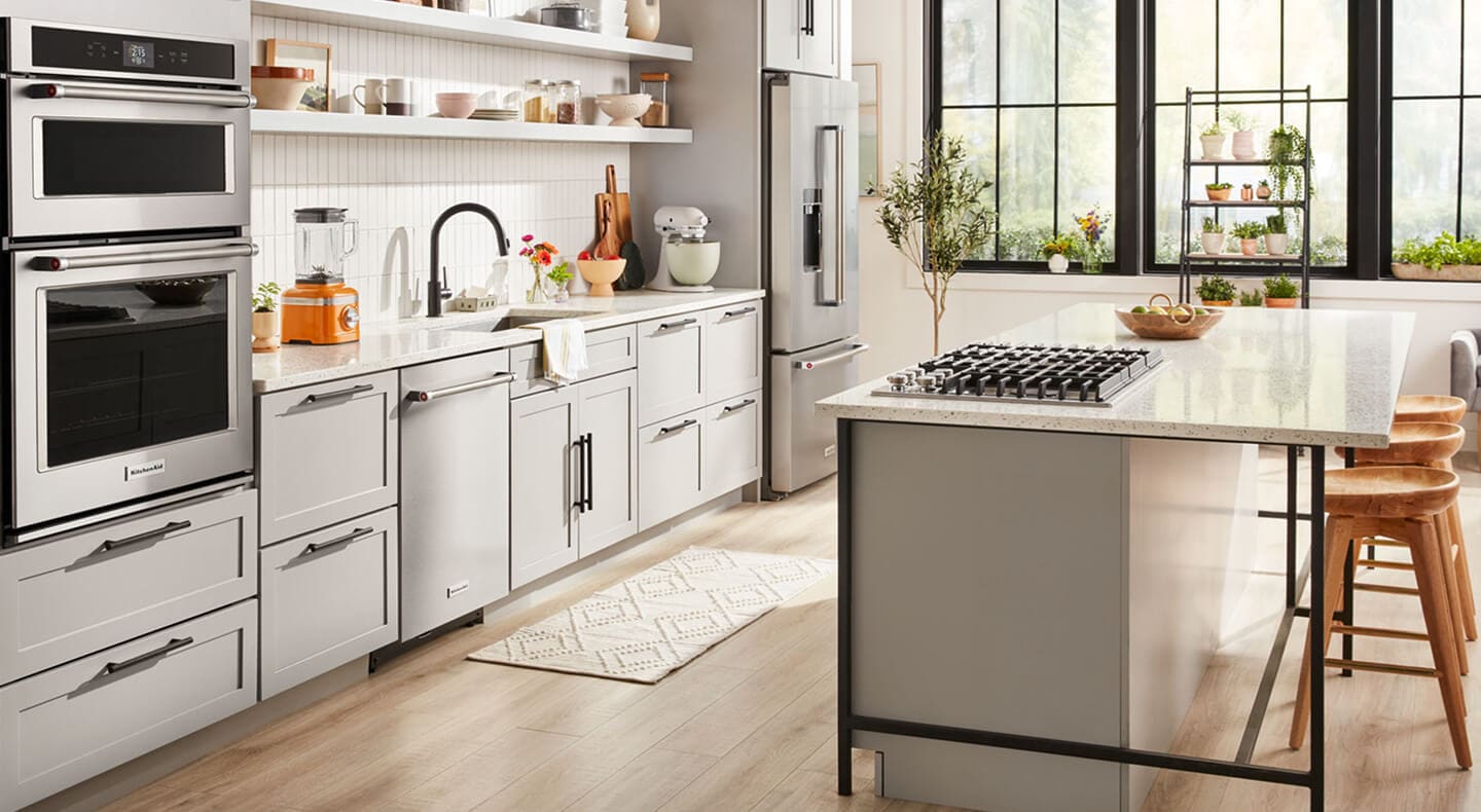 A bright kitchen with an island with a stovetop and stool seating A bright kitchen with an island with a stovetop and stool seating