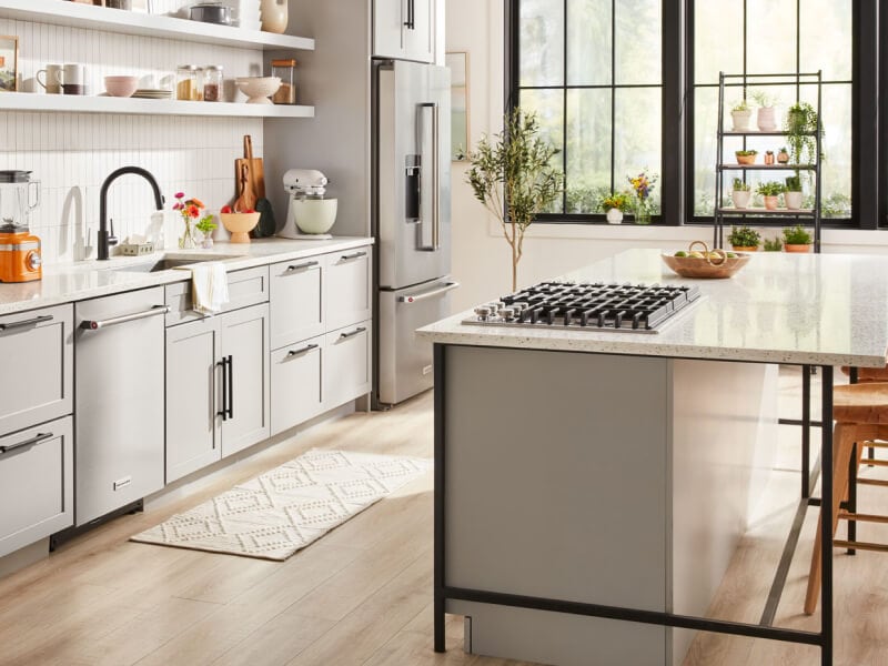 A bright kitchen with an island with a stovetop and stool seating A bright kitchen with an island with a stovetop and stool seating