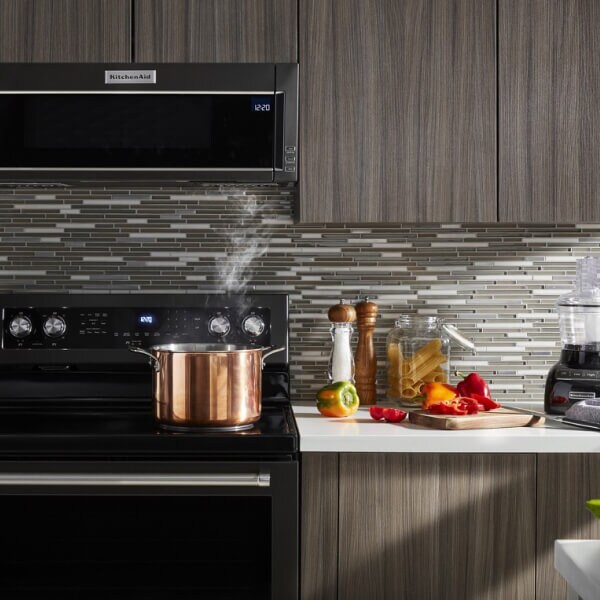 Stock pot heating on an electric stovetop below a KitchenAid® low profile microwave