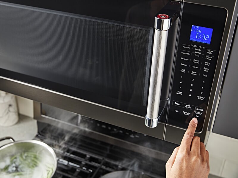 Person starting a cycle on a KitchenAid® microwave
