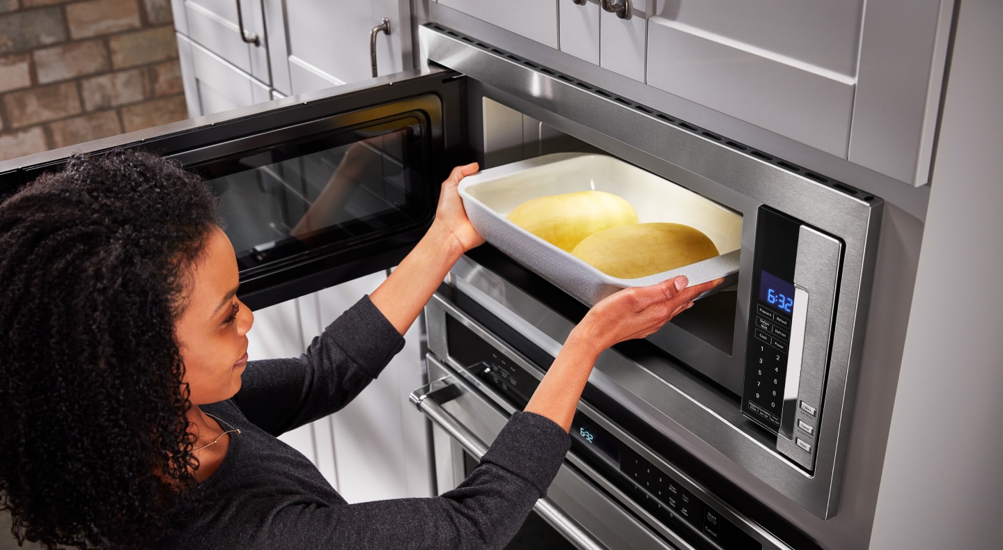 Person putting food into microwave Person putting food into microwave