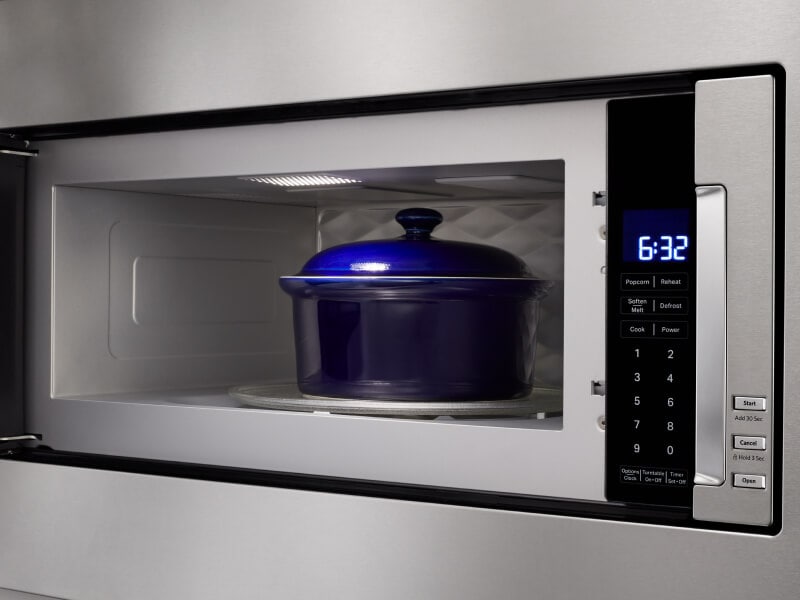 Blue dish inside microwave cavity with door open Blue dish inside microwave cavity with door open