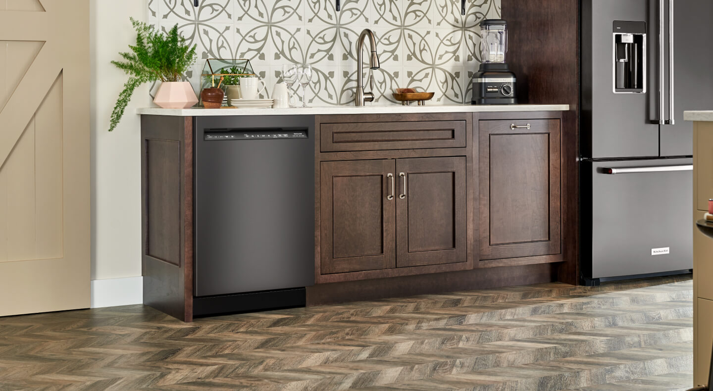 Black stainless steel KitchenAid® dishwasher next to a refrigerator