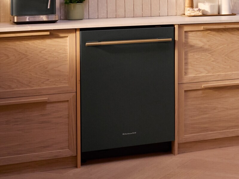 A KitchenAid® Third Rack Dishwasher with Juniper finish in cabinets of light wood
