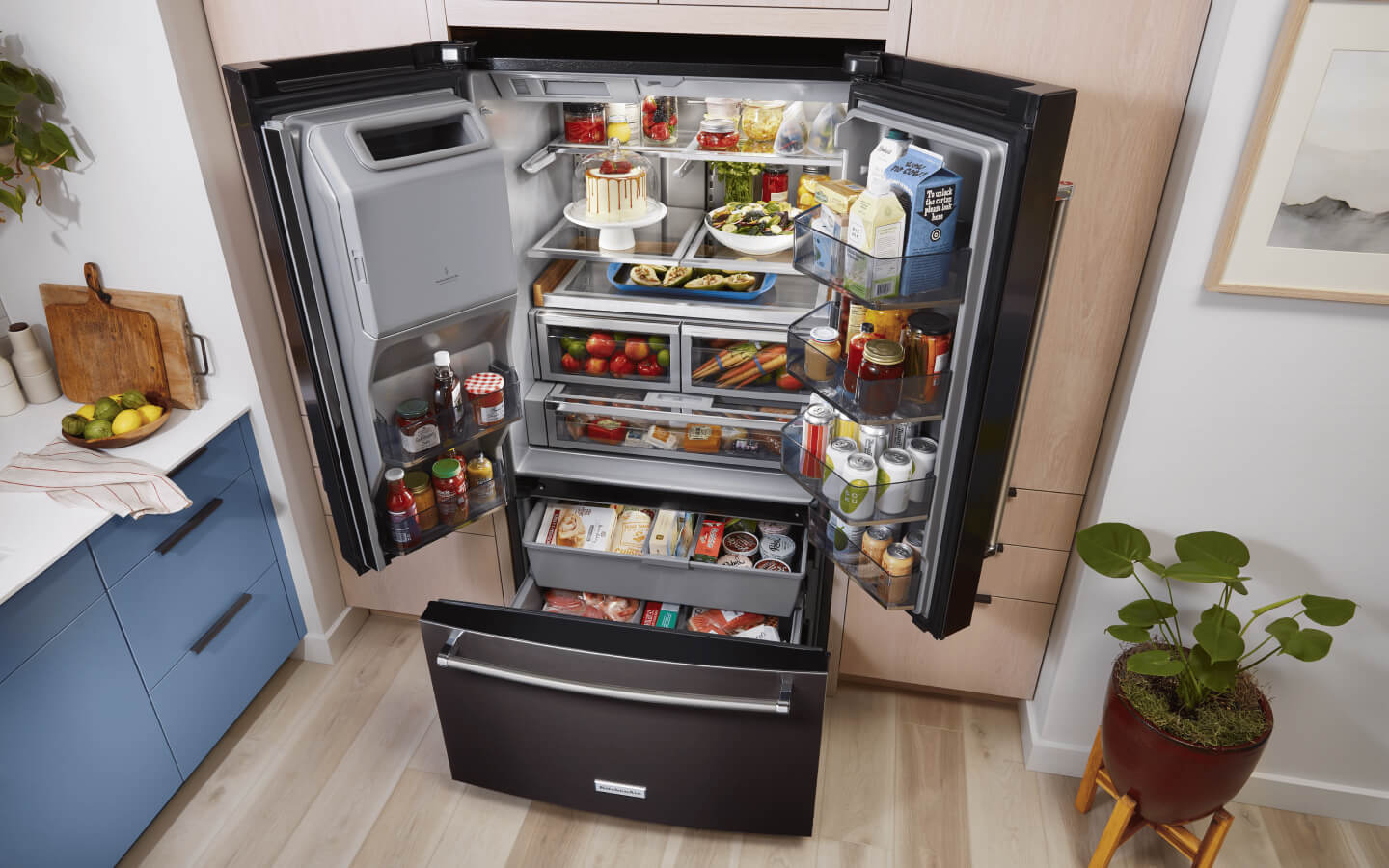 Angled birds-eye view of open and stocked French door refrigerator