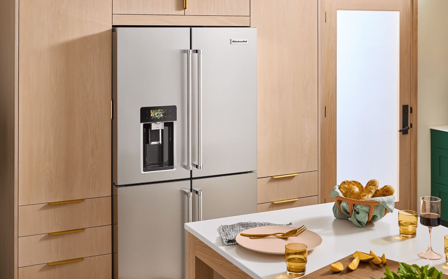 A stainless steel 4-door KitchenAid® refrigerator with an exterior ice and water dispenser