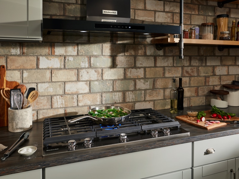 Black KitchenAid® canopy range hood over gas stovetop Black KitchenAid® canopy range hood over gas stovetop