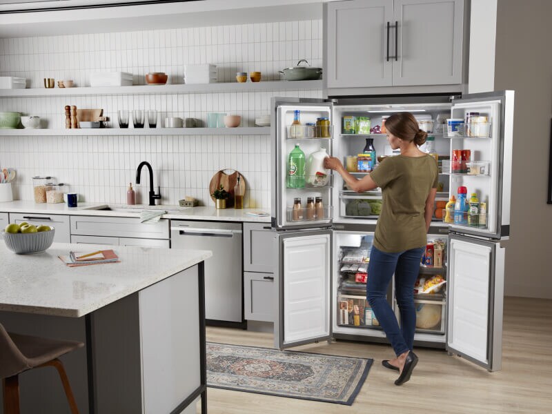 A person organizing a 4-door refrigerator