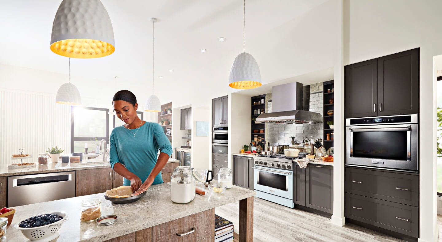 Person making a blueberry pie in their open kitchen Person making a blueberry pie in their open kitchen