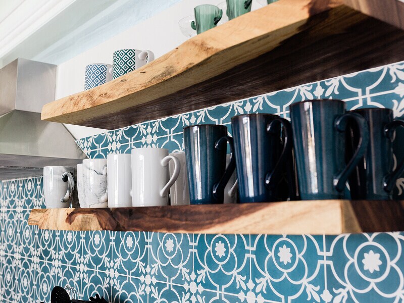 Mugs on floating wood shelves installed on a patterned wall Mugs on floating wood shelves installed on a patterned wall