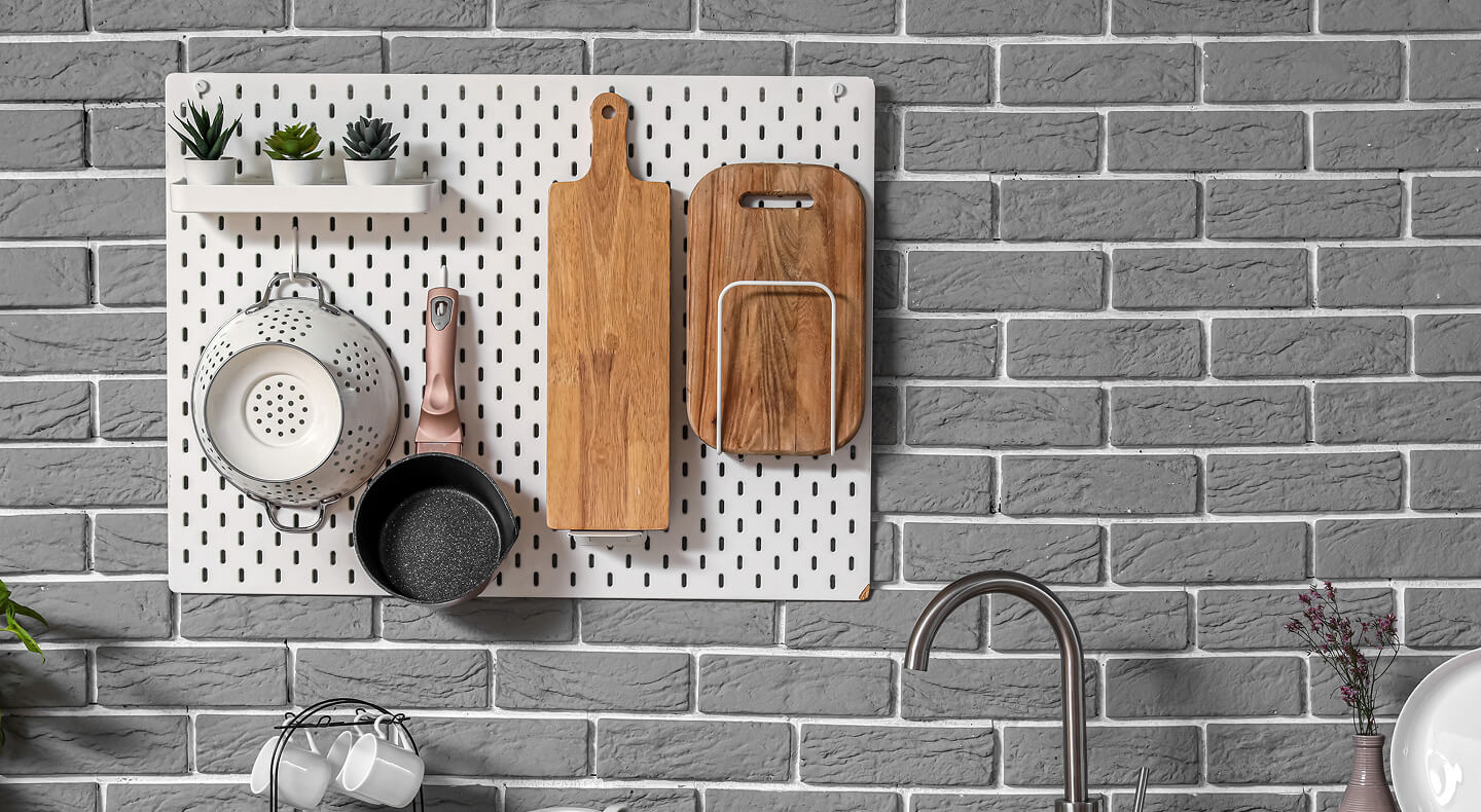Wood block cutting boards, a pot and a colander hanging on a peg board Wood block cutting boards, a pot and a colander hanging on a peg board
