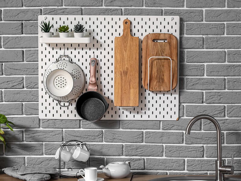 Wood block cutting boards, a pot and a colander hanging on a peg board Wood block cutting boards, a pot and a colander hanging on a peg board