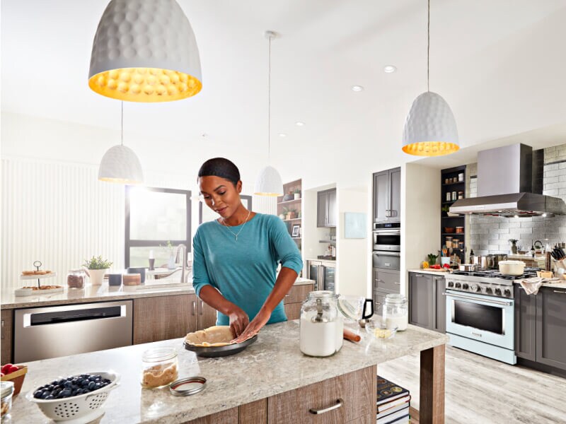 Person making a blueberry pie in their open kitchen Person making a blueberry pie in their open kitchen