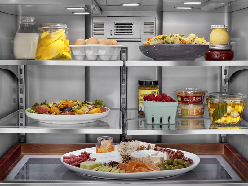 Interior of refrigerator with platters and side dishes organized inside