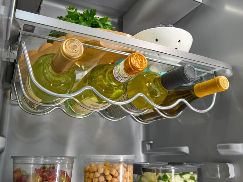 Close-up of a full wine storage rack inside a KitchenAid® refrigerator