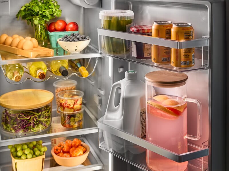 Beverages in door compartment of refrigerator stocked with fresh foods