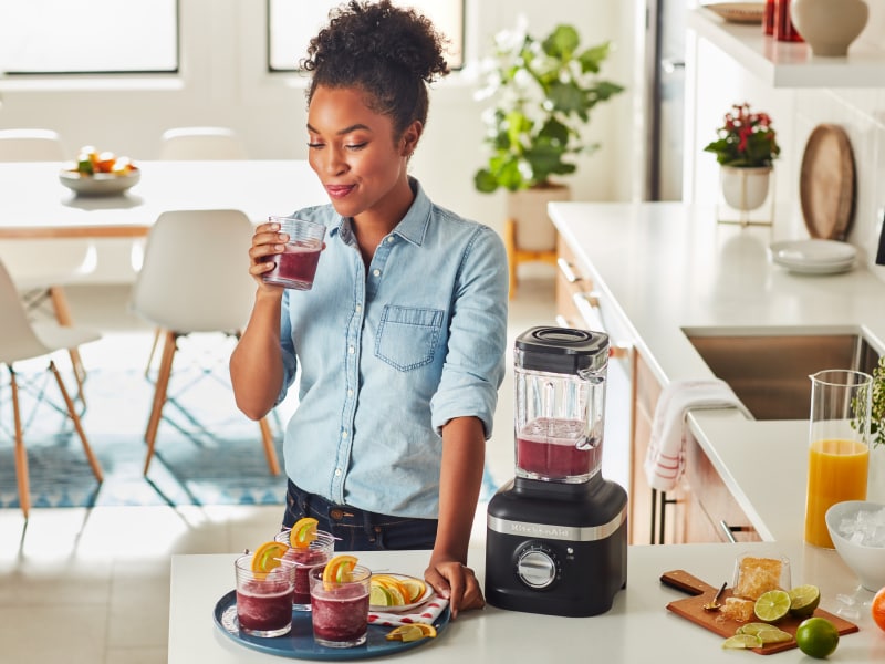 Person with KitchenAid® blender and frozen cocktails Person with KitchenAid® blender and frozen cocktails