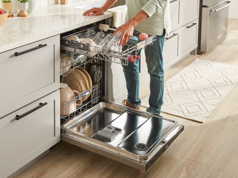 Person unloading third rack on dishwasher