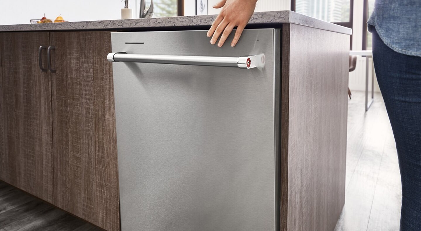 Person closing a top control dishwasher