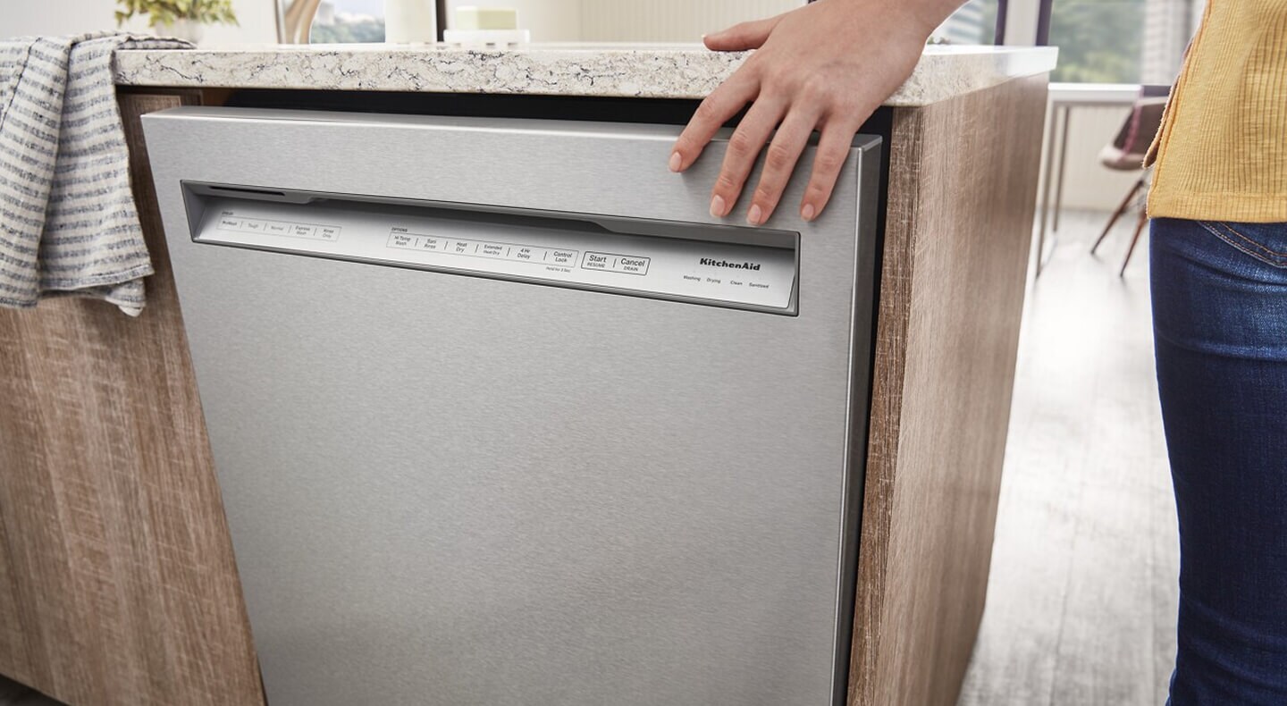 Person closing a front control dishwasher