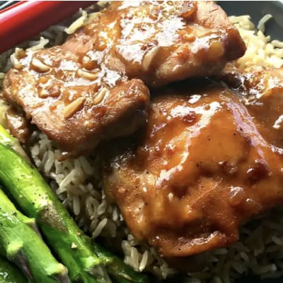 A plate of baked chai teriyaki chicken thighs over rice