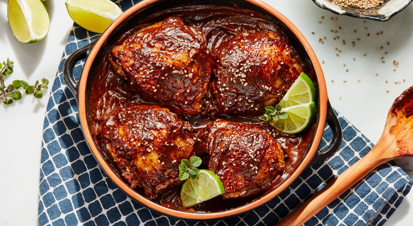 Chicken sitting in barbeque sauce marinade surrounded by lime wedges Chicken sitting in barbeque sauce marinade surrounded by lime wedges