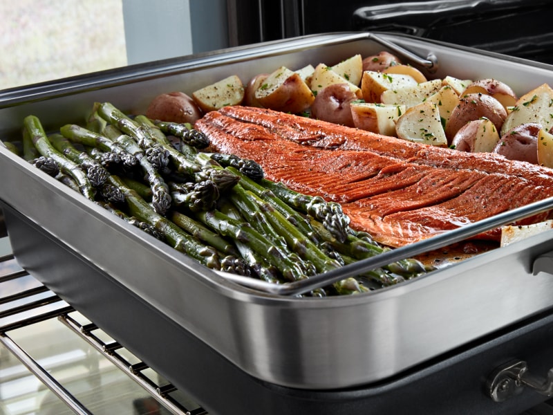 Salmon, potatoes and asparagus resting in a heating dish Salmon, potatoes and asparagus resting in a heating dish