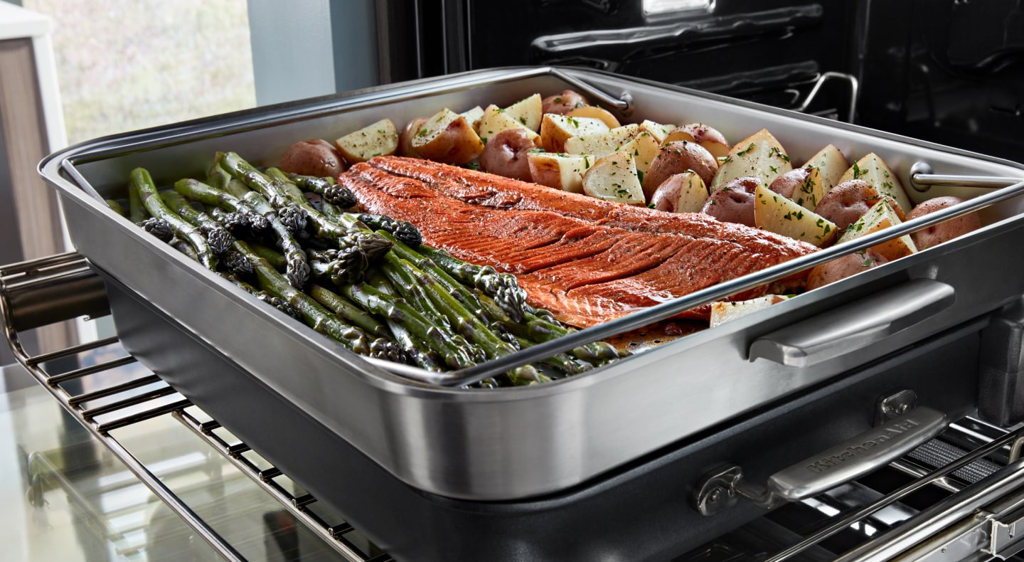 Salmon, potatoes and asparagus resting in a heating dish Salmon, potatoes and asparagus resting in a heating dish