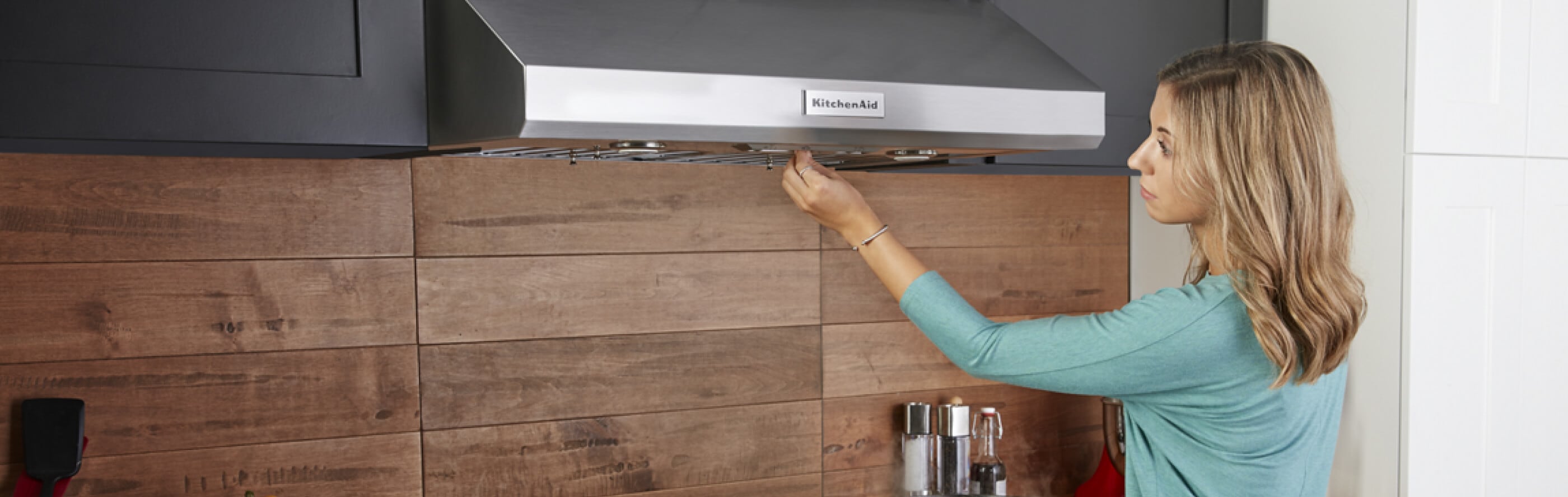 Person touching a wall-mount range hood